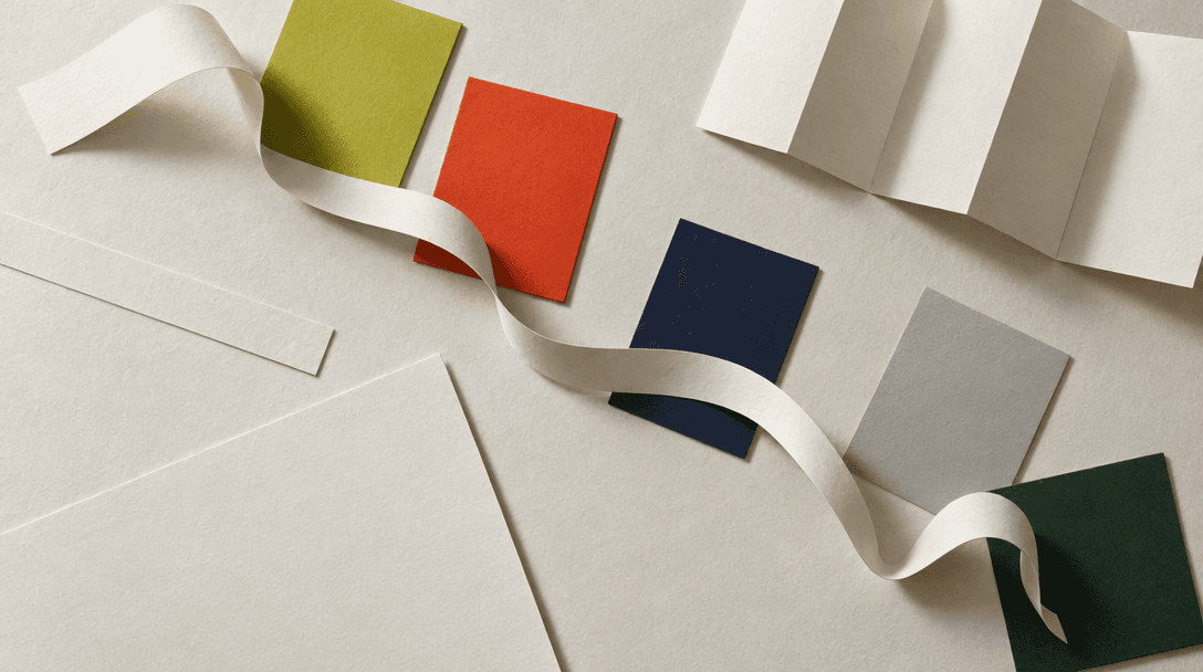 Paper color swatches, blank page layouts, and a curved paper strip arranged into one connected visual system